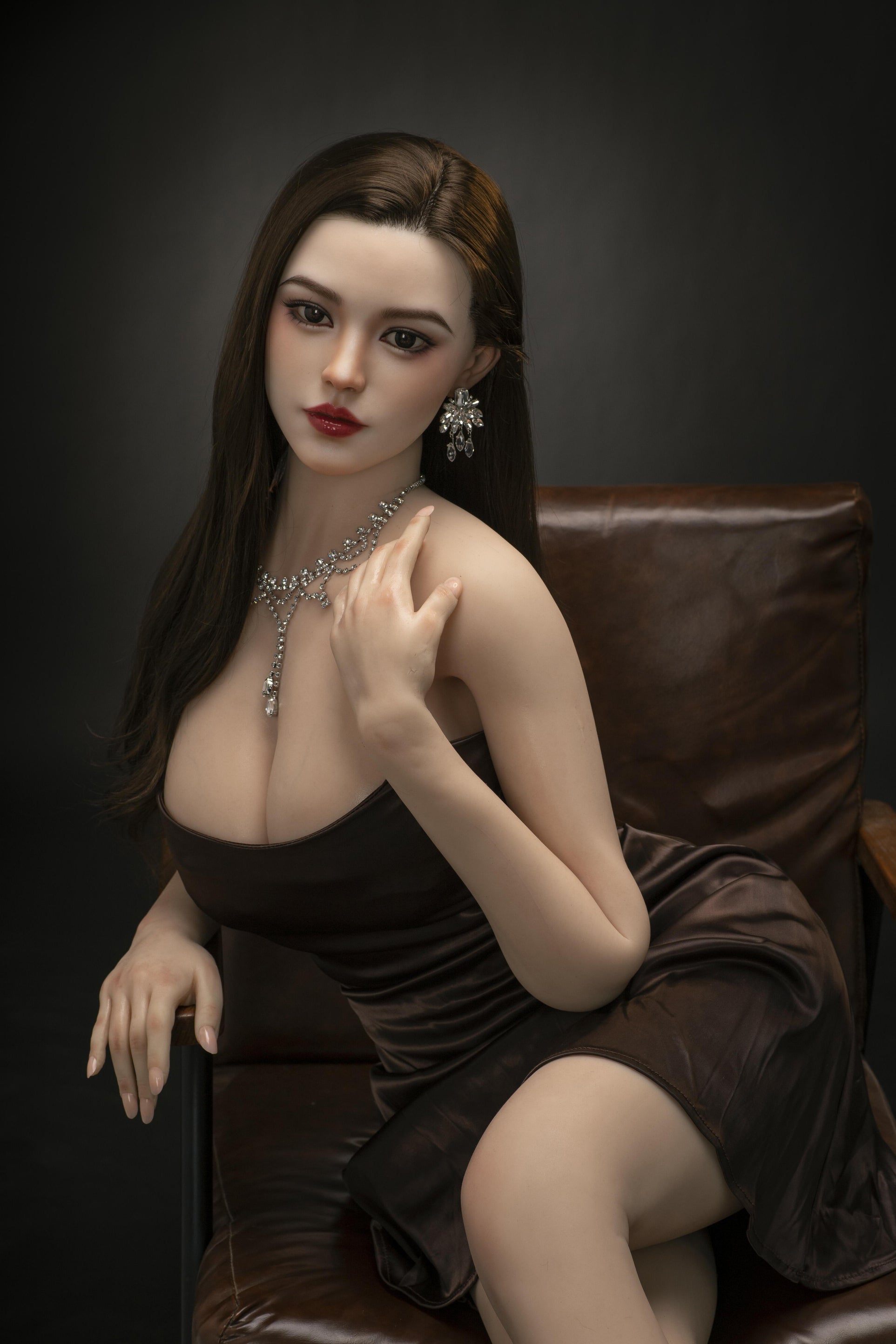 Sex Doll Lily in zwarte jurk op leren stoel
